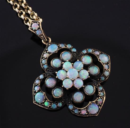 An early 20th century gold and white opal cluster pendant on a later 9ct gold chain, 1in.